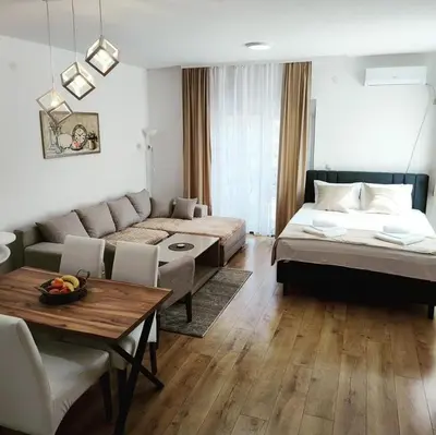 a living room with a couch and a bed and a table at SokoStar Lux in Soko Banja