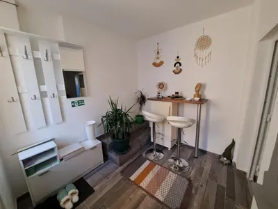 a white room with a table and a stool at Apartman Arsić Zajecar in Zaječar
