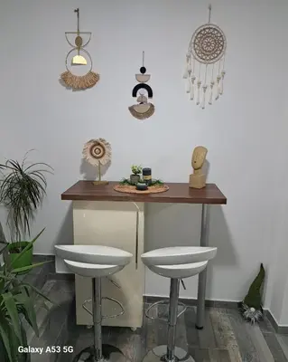 a kitchen with a bar with stools and a table at Apartman Arsić Zajecar in Zaječar