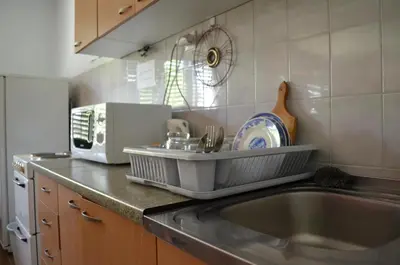 a kitchen counter with a sink and a microwave at Smeštaj - sobe MARVEL in Niš