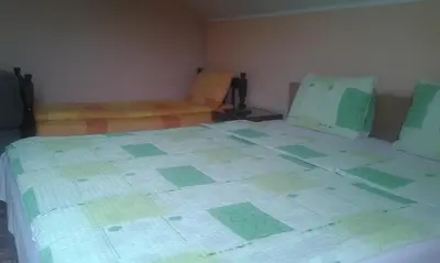 a bedroom with a large bed with green squares on it at Smeštaj - sobe MARVEL in Niš