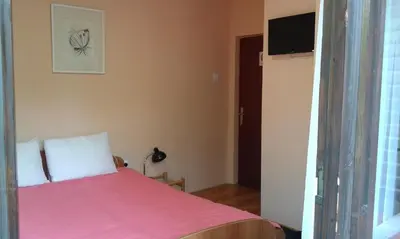 a bedroom with a bed with a pink blanket at Smeštaj - sobe MARVEL in Niš