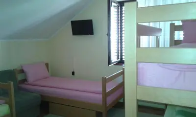 a room with a bunk bed and a bunk bed with a bench at Smeštaj - sobe MARVEL in Niš