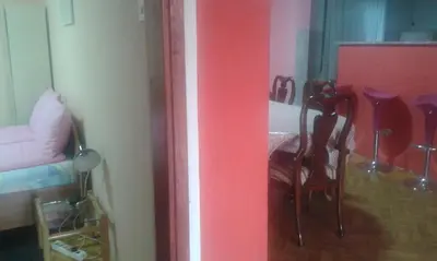 a room with a table and chairs and a red wall at Smeštaj - sobe MARVEL in Niš