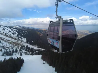 a gondola flying over a snow covered mountain at Regulus apartment Brzeće Kopaonik in Brzeće