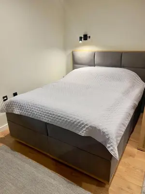 a bed in a bedroom with a white mattress at Regulus apartment Brzeće Kopaonik in Brzeće