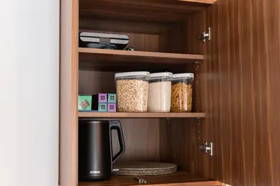 a cupboard filled with lots of containers of food at Glečer Kop, Cozy design apartment A5, FREE Parking Garage in Kopaonik