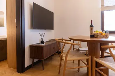 a dining room with a table and a tv at Glečer Kop, Cozy design apartment A5, FREE Parking Garage in Kopaonik