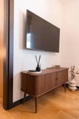a television on a wall above a wooden table at Glečer Kop, Cozy design apartment A5, FREE Parking Garage in Kopaonik