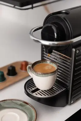 a cup of coffee is being brewed in a espresso machine at Glečer Kop, Cozy design apartment A5, FREE Parking Garage in Kopaonik