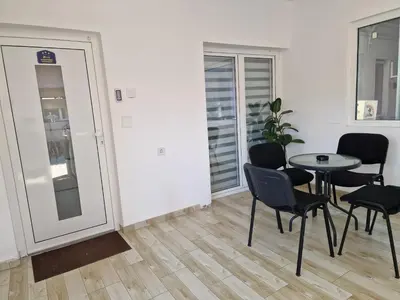 a room with a table and chairs and a window at Zed Apartments in Leskovac