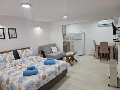 a bedroom with a bed and a living room at Zed Apartments in Leskovac