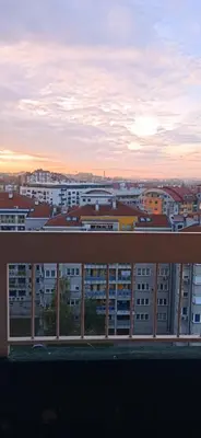 a view of a city at sunset from a building at Apartman Nissa in Niš