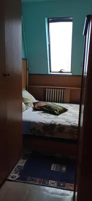 a small bedroom with a bed and a window at Apartman Nissa in Niš