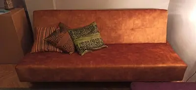 a red couch with two pillows on it at Apartman Nissa in Niš
