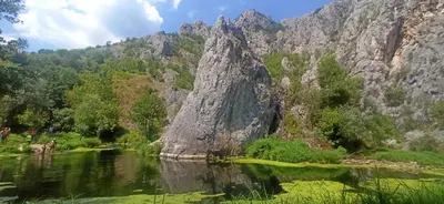 a mountain reflecting in the water of a river at Apartman Nissa in Niš