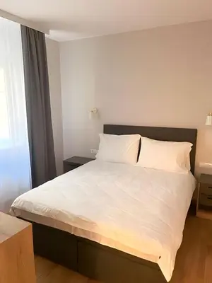 a bedroom with a large bed with white sheets at SUNSKII Apartments in Brzeće