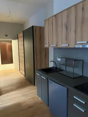 a kitchen with a black counter top and wooden cabinets at SUNSKII Apartments in Brzeće