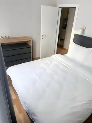 a bedroom with a large white bed and a desk at SUNSKII Apartments in Brzeće