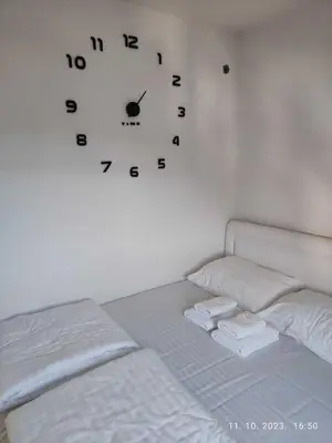 a clock hanging on a wall above a bed at Castello apartman Kopaonik Kraljevi Cardaci komplex in Kopaonik