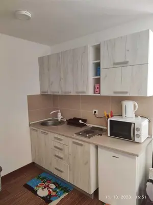 a small kitchen with a microwave and a sink at Castello apartman Kopaonik Kraljevi Cardaci komplex in Kopaonik