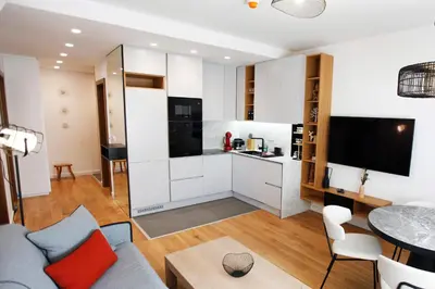 a kitchen and living room with a couch and a table at UrbanKop Vidik Residence in Kopaonik