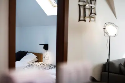 a bedroom with a bed and a lamp in a mirror at UrbanKop Vidik Residence in Kopaonik