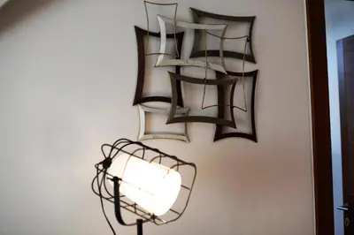 a light fixture hanging on a wall with a lamp at UrbanKop Vidik Residence in Kopaonik