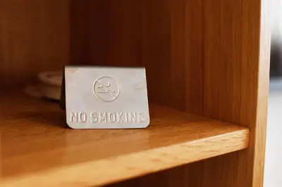a no smoking sign on a wooden shelf at UrbanKop Vidik Residence in Kopaonik
