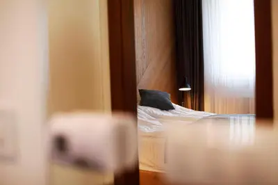 a reflection of a bedroom with a bed in a mirror at UrbanKop Vidik Residence in Kopaonik