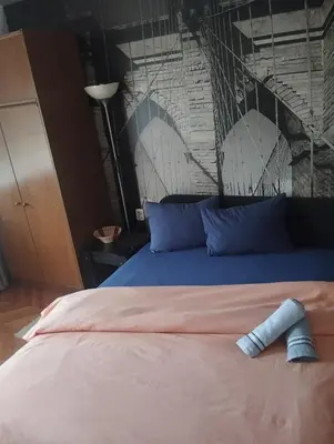 a bed with a blue pillow on top of it at Apartman Petra in Leskovac