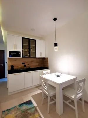 a kitchen with a white table and chairs at Golden Sky N Lux 57 Milmari Resort & Spa in Kopaonik