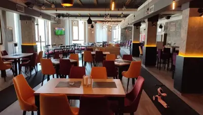 a restaurant with tables and chairs in a room at Golden Sky N Lux 57 Milmari Resort & Spa in Kopaonik
