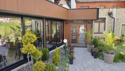 a restaurant with plants in front of a building at Golden Sky N Lux 57 Milmari Resort & Spa in Kopaonik