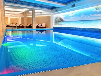 a swimming pool in a hotel with a mural of the ocean at Golden Sky N Lux 57 Milmari Resort & Spa in Kopaonik