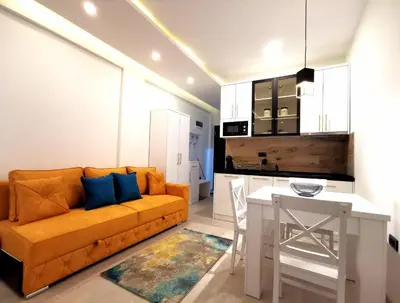 a living room with an orange couch and a table at Golden Sky N Lux 57 Milmari Resort & Spa in Kopaonik