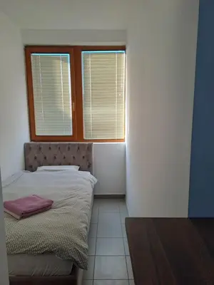 a bedroom with a bed and a window and a table at Sofi II in Niš