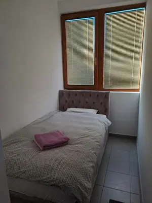 a bedroom with a bed with a purple blanket on it at Sofi II in Niš
