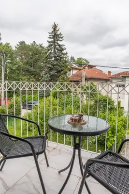 a table and chairs on a patio with a fence at Lucky Lux 1 i 2 Vrnjačka Banja in Vrnjačka Banja