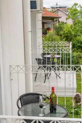 a table with two glasses of wine on a balcony at Lucky Lux 1 i 2 Vrnjačka Banja in Vrnjačka Banja