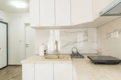 a kitchen with a sink and white cabinets at Lucky Lux 1 i 2 Vrnjačka Banja in Vrnjačka Banja