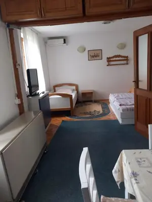 a room with two beds and a living room at Vila Verica in Vrnjačka Banja