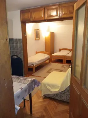 a room with two beds in a room with a door at Vila Verica in Vrnjačka Banja