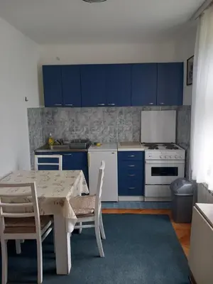 a kitchen with blue cabinets and a table and chairs at Vila Verica in Vrnjačka Banja