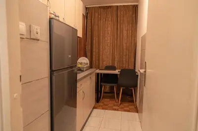 a kitchen with a refrigerator and a table with a dining room at Apartman TWO in Magnohrom