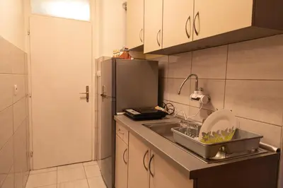 a kitchen with a sink and a refrigerator at Apartman TWO in Magnohrom