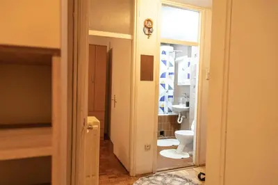a bathroom with a white toilet and a sink at Apartman TWO in Magnohrom