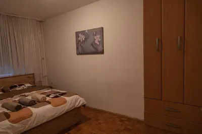 a bedroom with a bed and a painting on the wall at Apartman TWO in Magnohrom