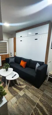 a living room with a black couch and a table at Marinkovic 2 stan na dan in Vranje