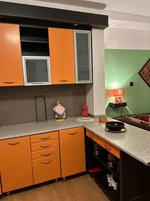 a kitchen with orange cabinets and a counter top at Jordan Apartman in Niška Banja